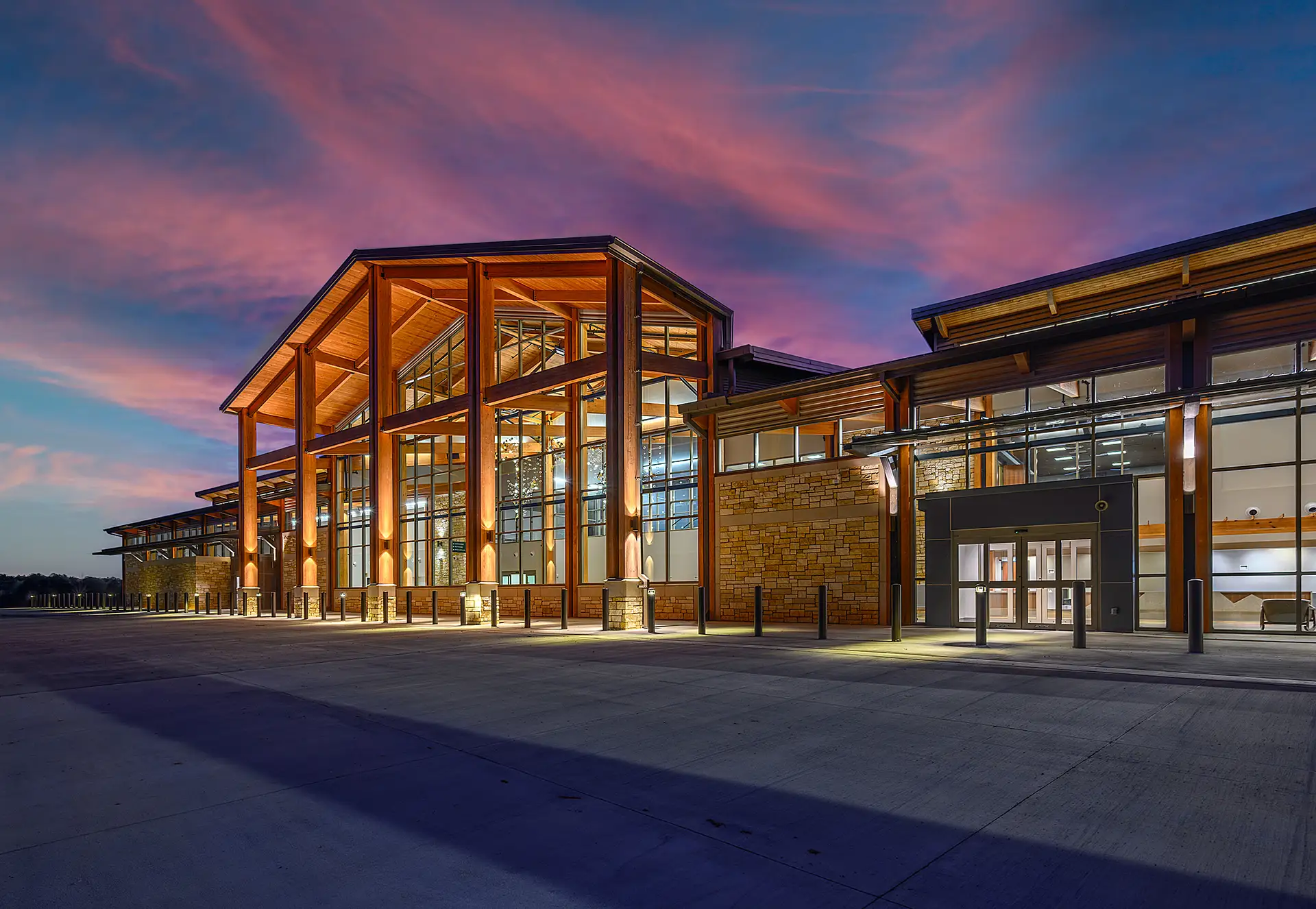 The Texarkana Regional Airport new passenger terminal building, curbside with a vivid pink and blue sunset