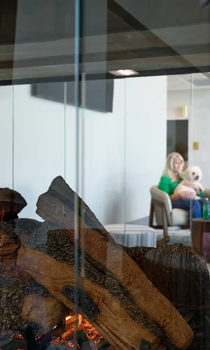 A male and female passenger sitting in the lobby of the Texarkana Regional Airport near the fireplace