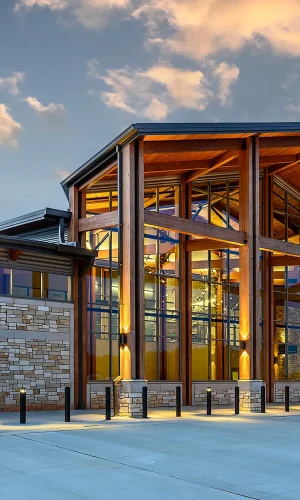 The new TXK Airport terminal building at sunrise, with beautiful outdoor lighting, tall ceilings, and wood treatments ready to welcome passengers.